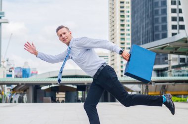 İş adamının acelesi var. Arka planda trafik saatinde bir sokakta hızla koşan bir evrak çantasıyla.