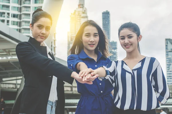 business woman showing unity putting hands together, linked by interest in a common cause, three entrepreneurs starting own small business, joint ventures, launching startup, team building