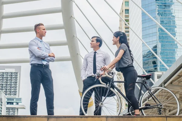 Lifestyle two business man and sport woman  with bicycle and talking is happy  in city background, Health riding bike