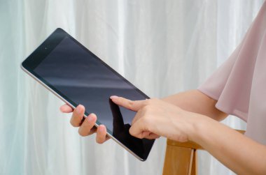 Kadın elinin evde tablet bilgisayarla, tabletle fotokopi aletiyle çekilmiş görüntüleri.