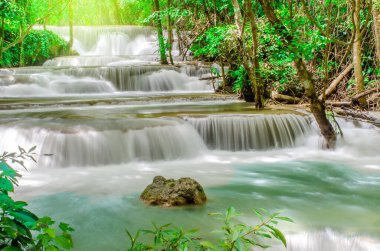 Tropikal yağmur ormanlarındaki güzel şelaleye, Tayland, Kanchanaburi 'deki Huai Mae Khamin Şelalesi' ndeki doğal parktaki derenin yumuşak suyuna seyahat edin..