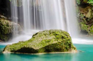 Soğuk nehir şelalesi taşların üzerine düşüyor, temiz mavi su Tayland 'daki Erawan parkının çağlayanlarına akıyor.
