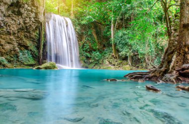 Erawan şelalesinde derin orman şelalesi, ormanın derinliklerinde güneş ışınları olan güzel şelale, Tayland, Kanchanaburi 'deki Erawan Ulusal Parkı.