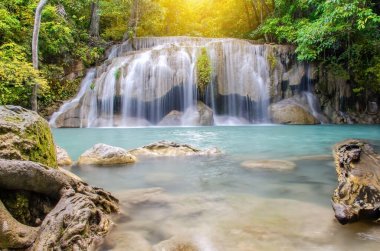Erawan şelalesinde derin orman şelalesi, ormanın derinliklerinde güneş ışınları olan güzel şelale, Tayland, Kanchanaburi 'deki Erawan Ulusal Parkı.