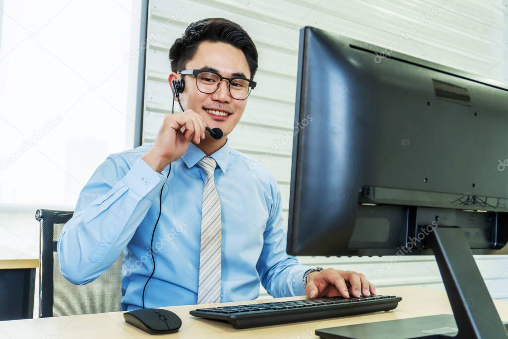 Call center, Service desk consultant talking on hands-free phone,  Portrait of happy smiling male customer support phone operator at workplace, Call center business man talking on headset, Office and business concept