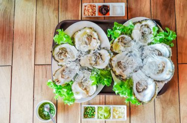 Limon ve ızgara soğanla servis edilen taze istiridyeler bir restoranda, deniz ürünleri menüsü tasarımı, Tayland usulü, üst manzara..