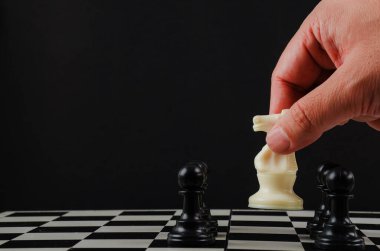 El adam satranç tahtasında beyaz atla hamle yapıyor.