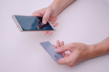 Çevrimiçi ödeme, kapanış genç adam elleri bir kredi kartı tutuyor ve online alışveriş için akıllı telefon kullanıyor ya da kayıp kartı bildirmek arka plan dışı bir şehir, yeni nesil aygıt