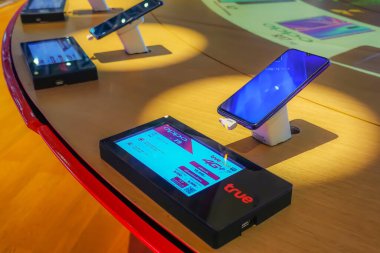 BANGKOK, THAILAND - 7 Nisan 2019: TRUE modern elektronik mağazasında akıllı telefonlu gösteri. Bir cep telefonu al. TRUE teknoloji mağazasının rafında birçok akıllı telefon var.