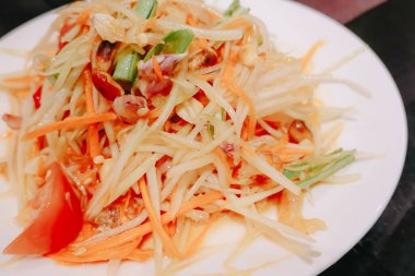Yeşil papaya salatasını veya beyaz tabakta Som tum Thai 'yi, Tayland' da popüler somtum salatasını kapat (geleneksel ve modern Tayland yemekleri)