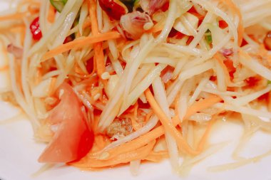 Yeşil papaya salatasını veya beyaz tabakta Som tum Thai 'yi, Tayland' da popüler somtum salatasını kapat (geleneksel ve modern Tayland yemekleri)