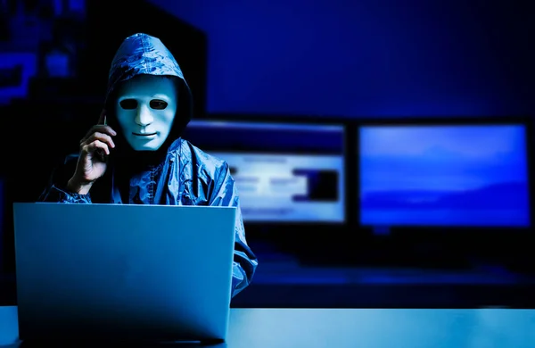 Beyaz maskeli ve kapüşonlu isimsiz bilgisayar korsanı. Siber saldırı için dizüstü bilgisayar kullanan ve cep telefonu, veri hırsızı, internet saldırısı, darknet ve siber güvenlik kavramını kullanan karanlık yüz..