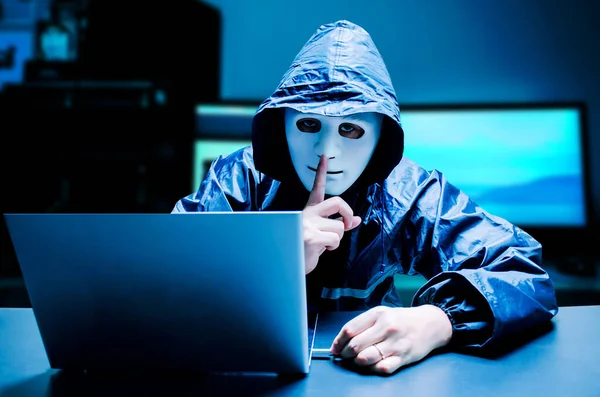 Beyaz maskeli ve kapüşonlu isimsiz bilgisayar korsanı. Karanlık yüz sessiz hareketler yaparak karanlık arka planda USB bellek, veri hırsızı, internet saldırısı olan bilgisayardan bilgi sistemi verilerini hacklemeye ve çalmaya çalışıyor..
