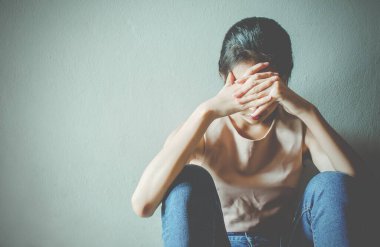 Depresyonda olan genç bir kız çocuğu acı çekerken karanlık odada yalnız başına oturmak, aile içi şiddet, stres, şiddet depresyon ve intihar kavramı..