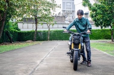 Gündüzleri yanında klasik motosiklet süren yakışıklı adamın ön görüntüsü..