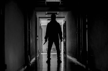 Cinayet, cinayet ve insan konsepti - suçlu ya da katil cinayet mahallinde bıçaklı bir maske takıyor.
