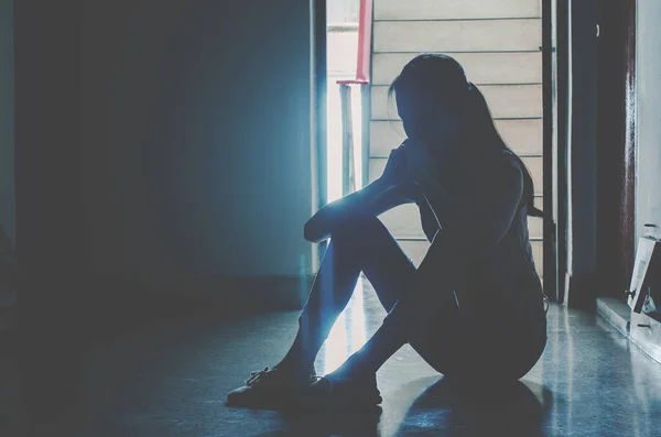 女孩独自坐在黑暗中的轮廓 悲伤而严肃的女人独自坐在他的膝上拥抱他的旧公寓 家庭暴力 家庭问题 抑郁和自杀的概念 — 图库照片