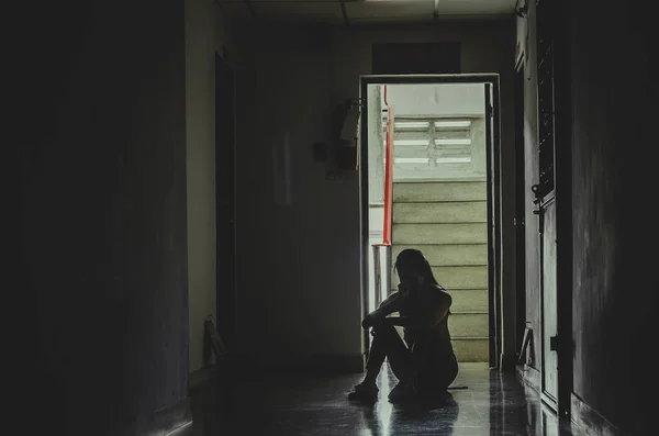 女孩独自坐在黑暗中的轮廓 悲伤而严肃的女人独自坐在他的膝上拥抱他的旧公寓 家庭暴力 家庭问题 抑郁和自杀的概念 — 图库照片