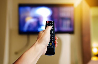 TV izlemek için el ele tutuşan televizyon ve ses multimedya uzaktan kumandası 