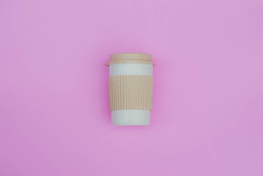 Pembe pastel arka plandaki kahve fincanının üst görüntüsü. Düz yatıyordu. Boşluğu kopyala