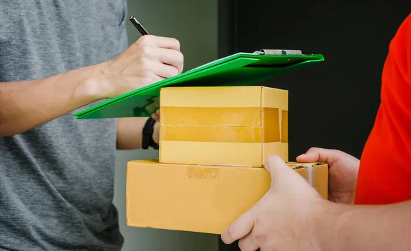 Postacı eve mal teslimatı, teslimatçı, ev teslimatı konsepti, paketleri alıcılara hızlı bir şekilde, eksiksiz ürünler, etkileyici hizmetler teslim etmek için imzayı atıyor.