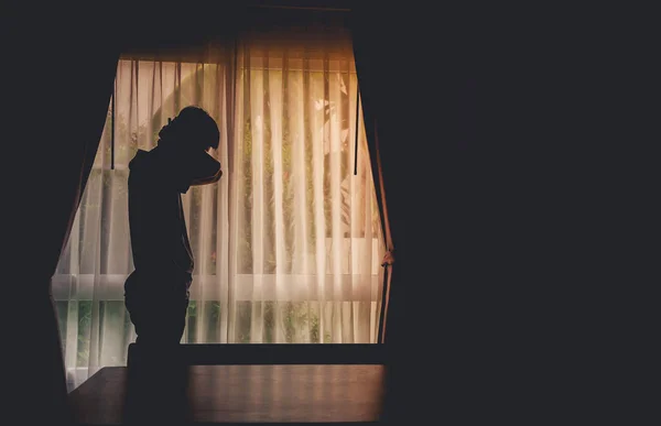 一个人站在窗前 只有一个人站在窗前 窗帘紧闭在黑暗的房间里 男人独自站在窗前 忧郁症和焦虑症的概念 — 图库照片