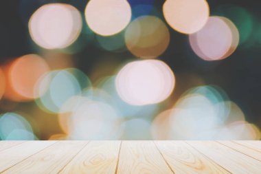 Soyut renkli bokeh gece lambası arka planında boş ahşap masa zeminleri Noel için şenlikli bir süsleme