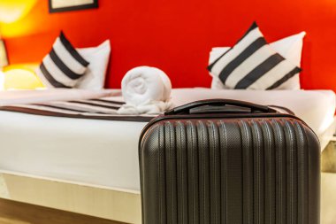 Otel odasında geniş teleskobik saplı tek bir siyah plastik kabuk valizi ve iş seyahati için hazırlanmış bir bavul. Yalnız seyahat konsepti. metin için boşluk kopyala