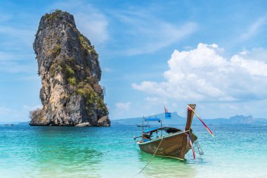 Railay, Tayland - 15 Şubat 2020: Koh Poda adasındaki kumsalda iki kadın turist ve uzun kuyruk teknesi. Ao Nang, Krabi adası Tayland 'ın en popüler turistik yeridir.