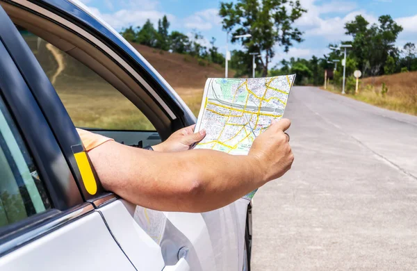 Road trip, Traveler man on vacation looking at map for directions while driving in car, Person Traveler Travel Destination Concept