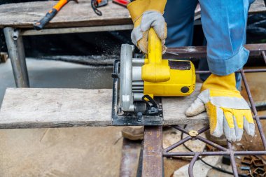 Marangoz elektrikli aletlerle ahşap tahtaları kesmek için dairesel testere kullanıyor, inşaat ve ev yenileme, onarım ve inşaat aletleri