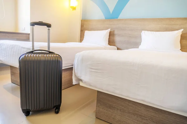 Black travel suitcase or luggage bag in a modern hotel room - relaxing time, holidays, weekend and traveling concept.