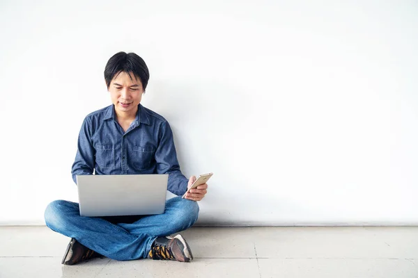 Молодой Человек Азиат Сидит Полу Помощью Компьютера Ноутбука Мобильного Телефона — стоковое фото