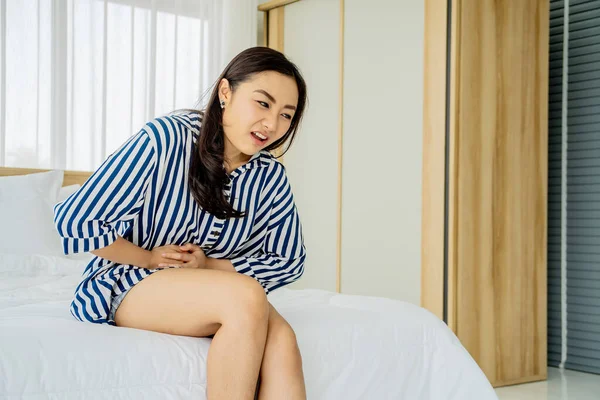 Infeliz Joven Asiático Mujer Sufrimiento Estómago Dolor Mientras Sentado Cama —  Fotos de Stock