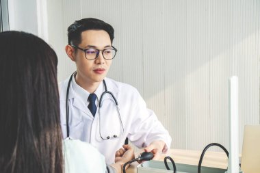 Sağlık, hastane ve ilaç konsepti - hastanedeki hastasının tansiyonunu ölçen doktor