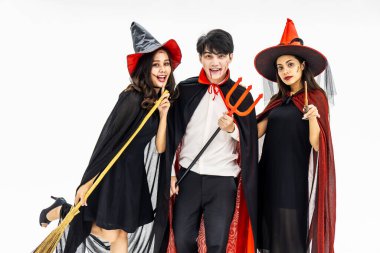 Cadılar Bayramı için farklı kostümler giyen üç genç insan, beyazlar içinde izole edilmiş.