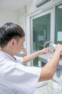 Bilim adamları Noel Baba 'yı cam bir tüpün içine damlatıyor. Seçici odak, parlak neon, parlak oda.