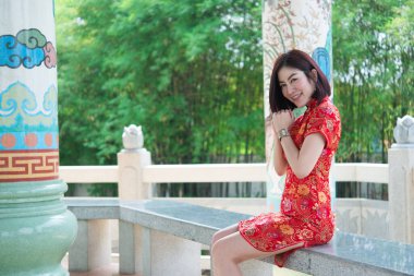 Cheongsam elbiseli, Taylandlı güzel Asyalı kadın, Mutlu Çin Yeni Yılı konsepti.
