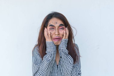 Güzel Asyalı kadın beyaz arka planda yüz esprisi yapıyor, Taylandlılar fotoğraf için poz veriyor.