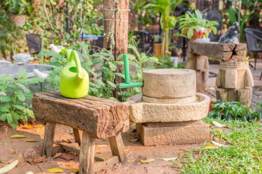 Bahçedeki bankta Green Waterring konservesi. Makara, ağaçlar.
