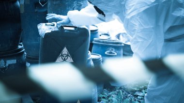 Asyalı bilim adamı kimyasal koruma giysisi giyiyor. Tehlikeli bölgelerde çalışan tehlikeli kimyasalları kontrol ediyor.