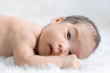 Kapalı Asyalı bebek Halı yününde yatıyor