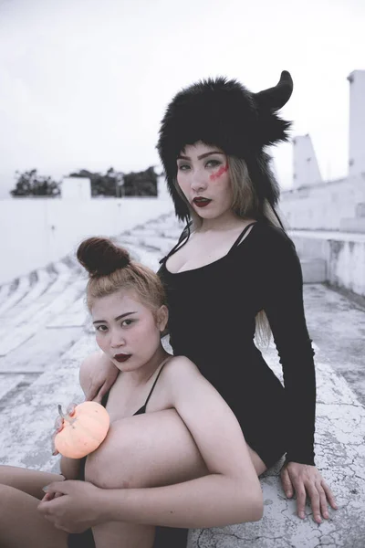 Two Scary sexy girl in black dress outdoor  halloween concept,from back,dark tone,black and white,low key,dark concept
