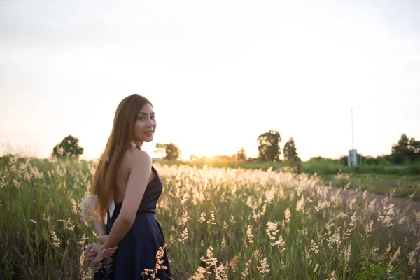 Beautiful girl on the flowers field on sunset Soft focus,grass flowers in her hand,asian girl,vintage style,dark tone,film,pastel