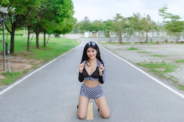 Beautiful asian sexy woman in black dress with umbrella outdoor,Pretty thailand racing dress style portrait