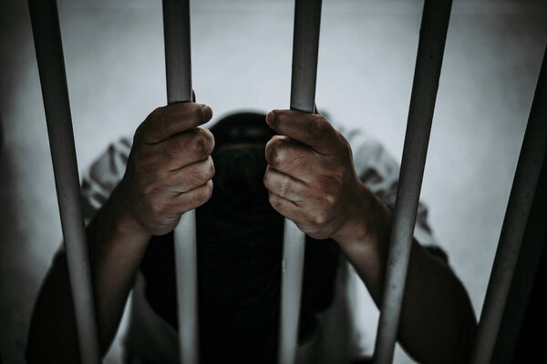 Руки человека, отчаянно пытающегося поймать железную тюрьму, концепцию заключенных, таиландцев, Надежда на свободу
.