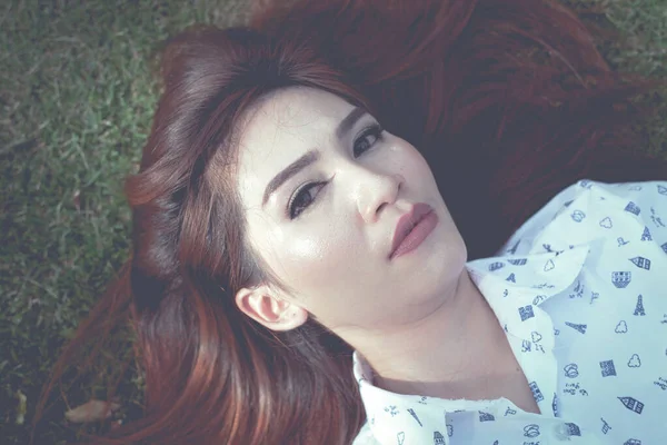 緑の草の上の若いアジア人女性の肖像画 — ストック写真