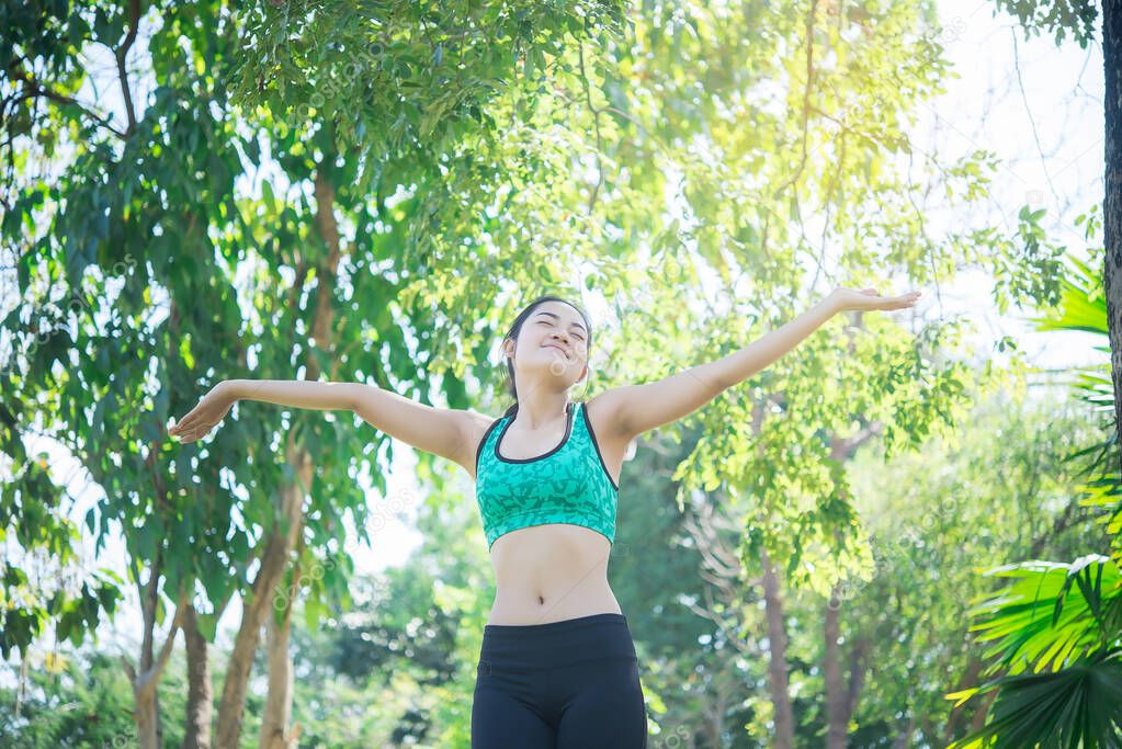 Asian sporty woman stretching arms breathing fresh air at mountain with beautiful sky,Thailand people