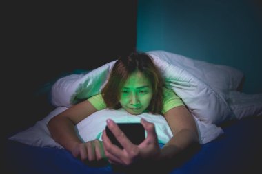 Asyalı kadın gece yatakta akıllı telefon çalar, Taylandlılar...