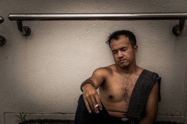 Asyalı, yakışıklı, sigara içen, Taylandlı, bunalımlı adam konsepti, şirketinin işi hakkında endişeleniyor.